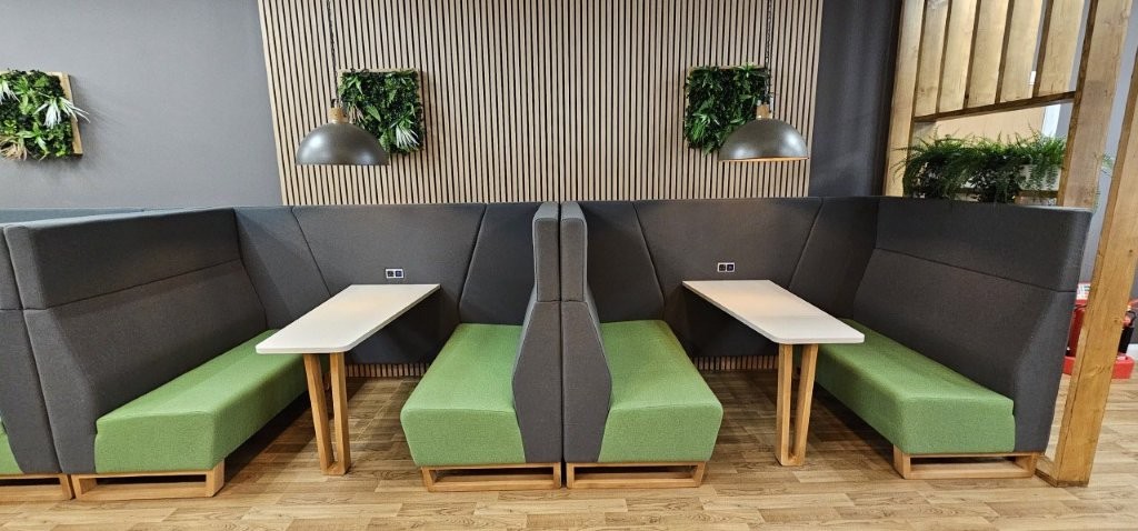 Meeting pods with green seats and industrials pendant lights